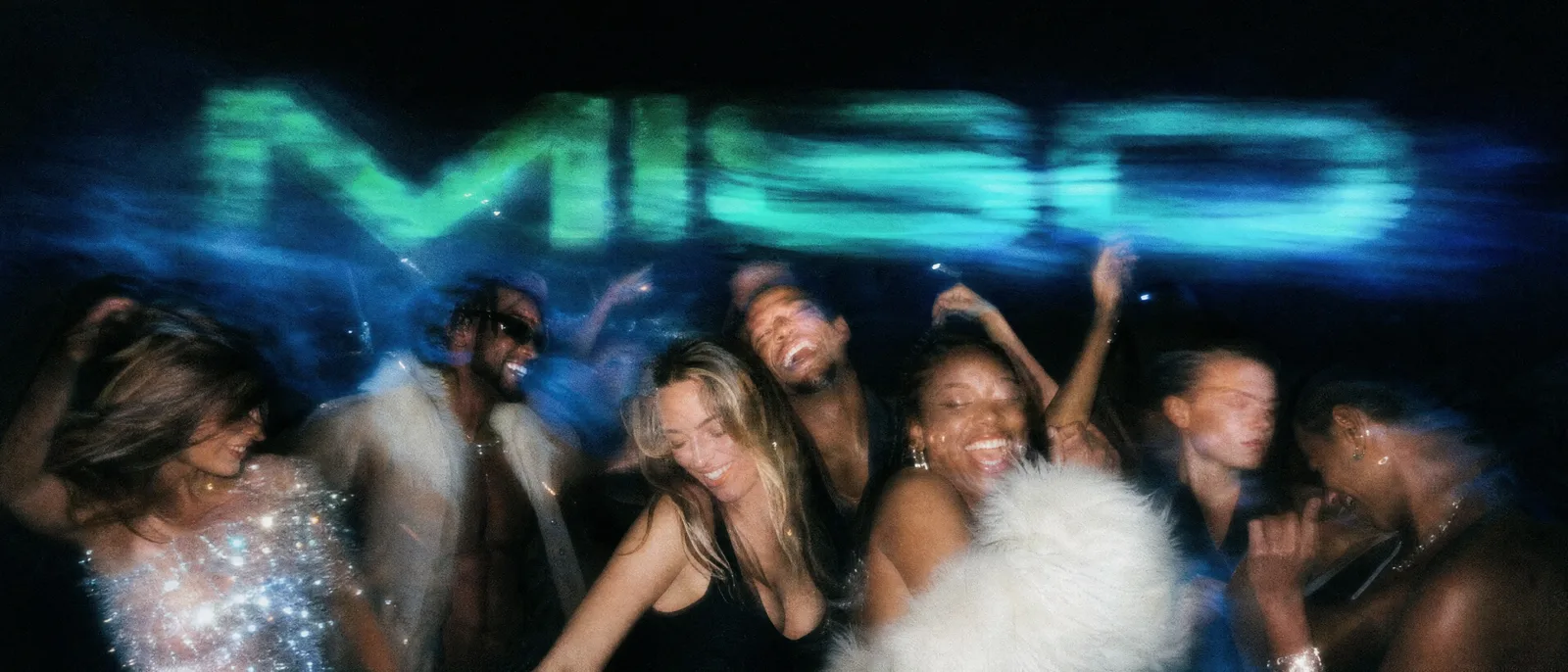 A crowd dancing under lights at a night event